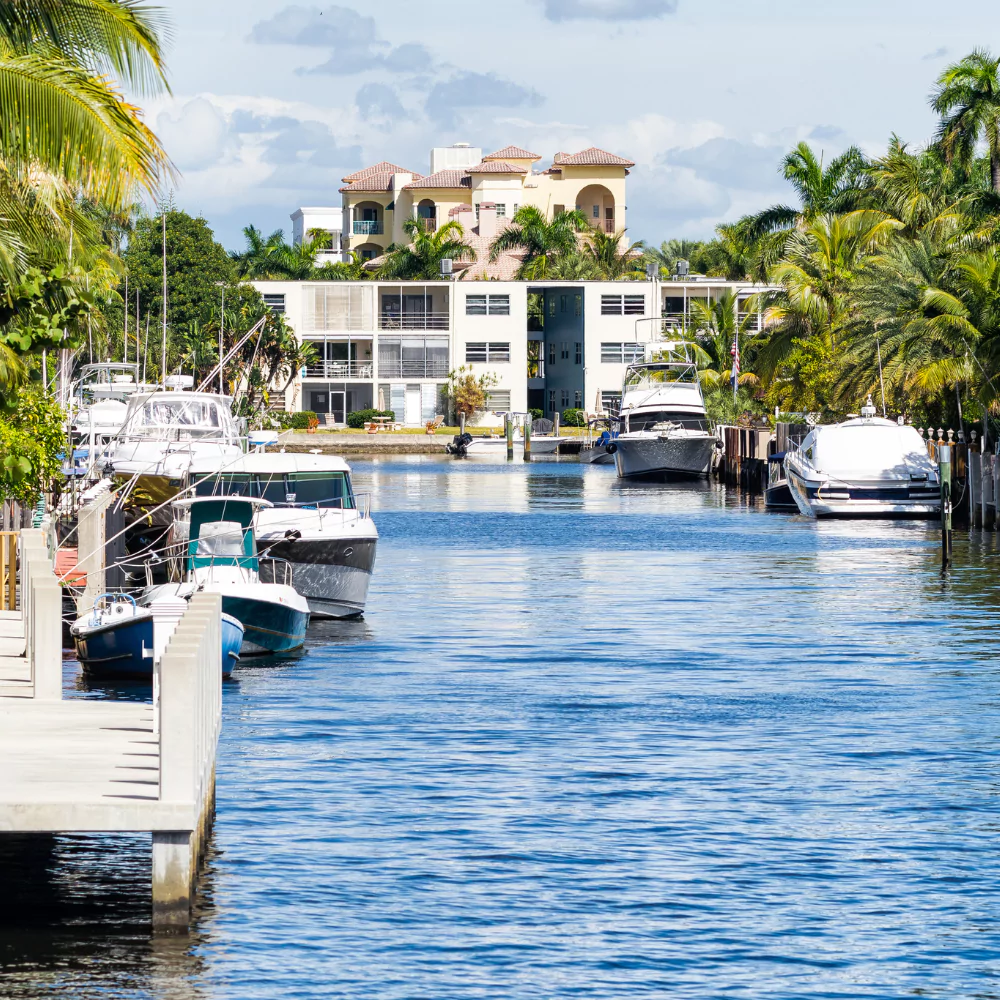 Canal with docked boats and waterfront houses.