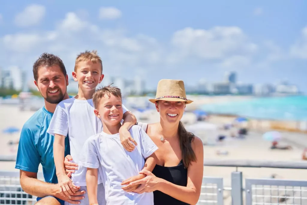 Smiling family at the beach with ocean view.