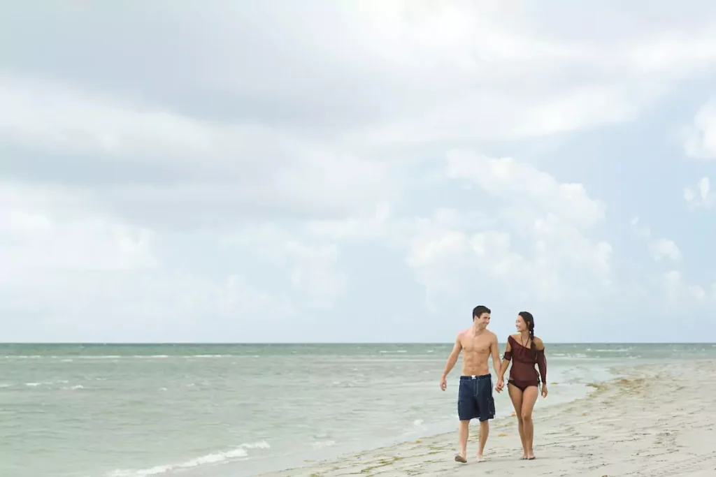 Couple walking hand-in-hand on the beach.